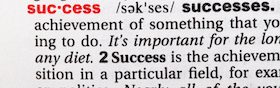 Closeup of English dictionary page with word success.